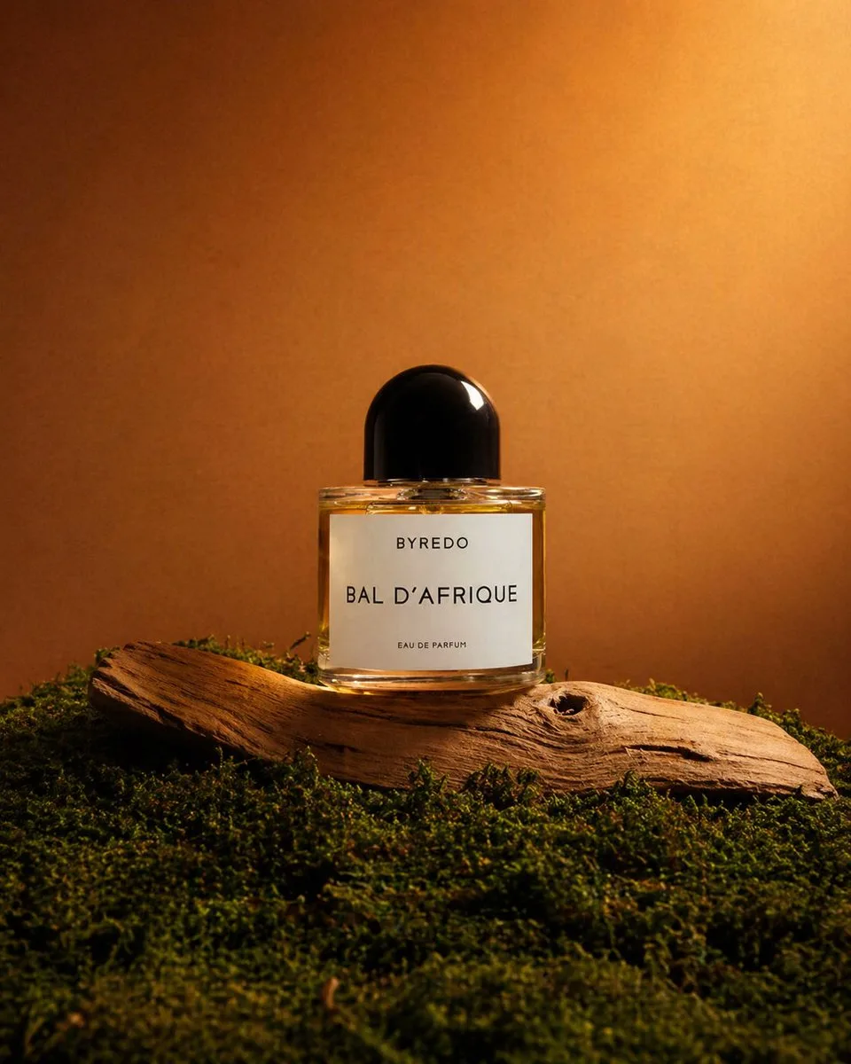 Luxury perfume bottle on driftwood and moss with warm sunset lighting