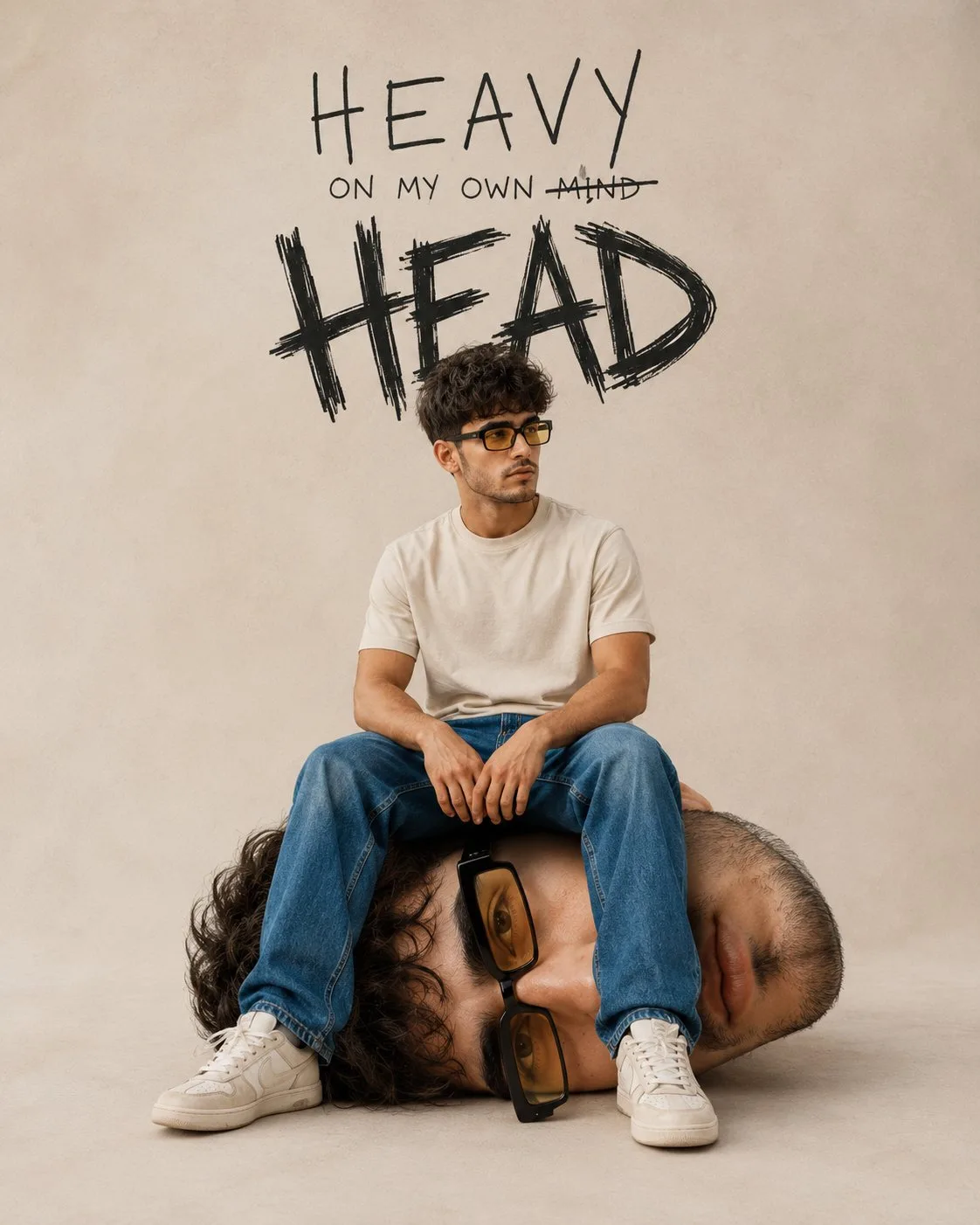 A man sitting on a giant replica of his own head in a minimal studio.