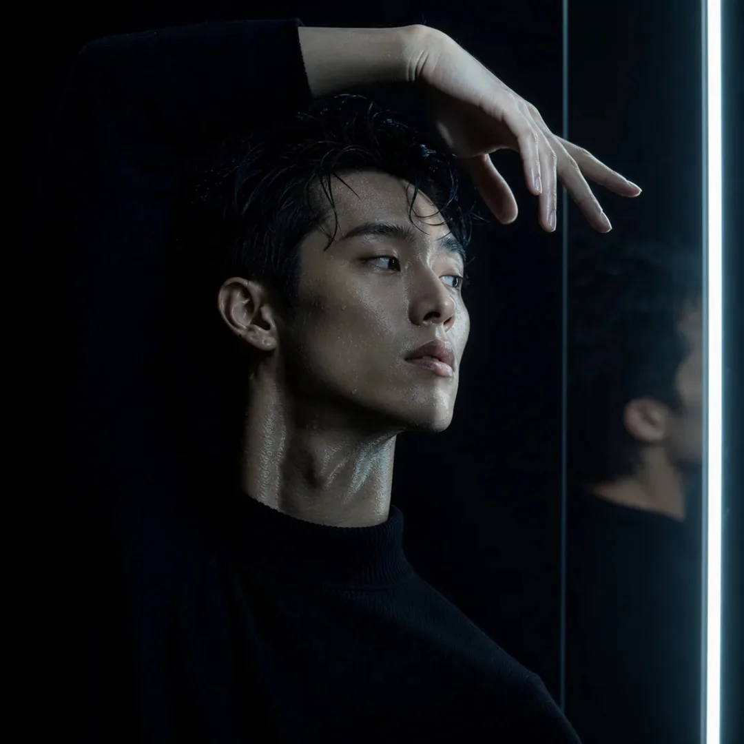 Male contemporary dancer striking a dramatic pose under cold side lighting.