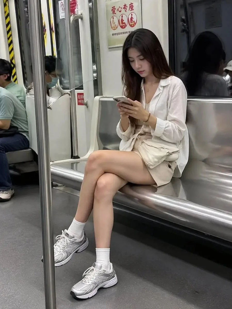 A woman looking at her phone while riding the subway