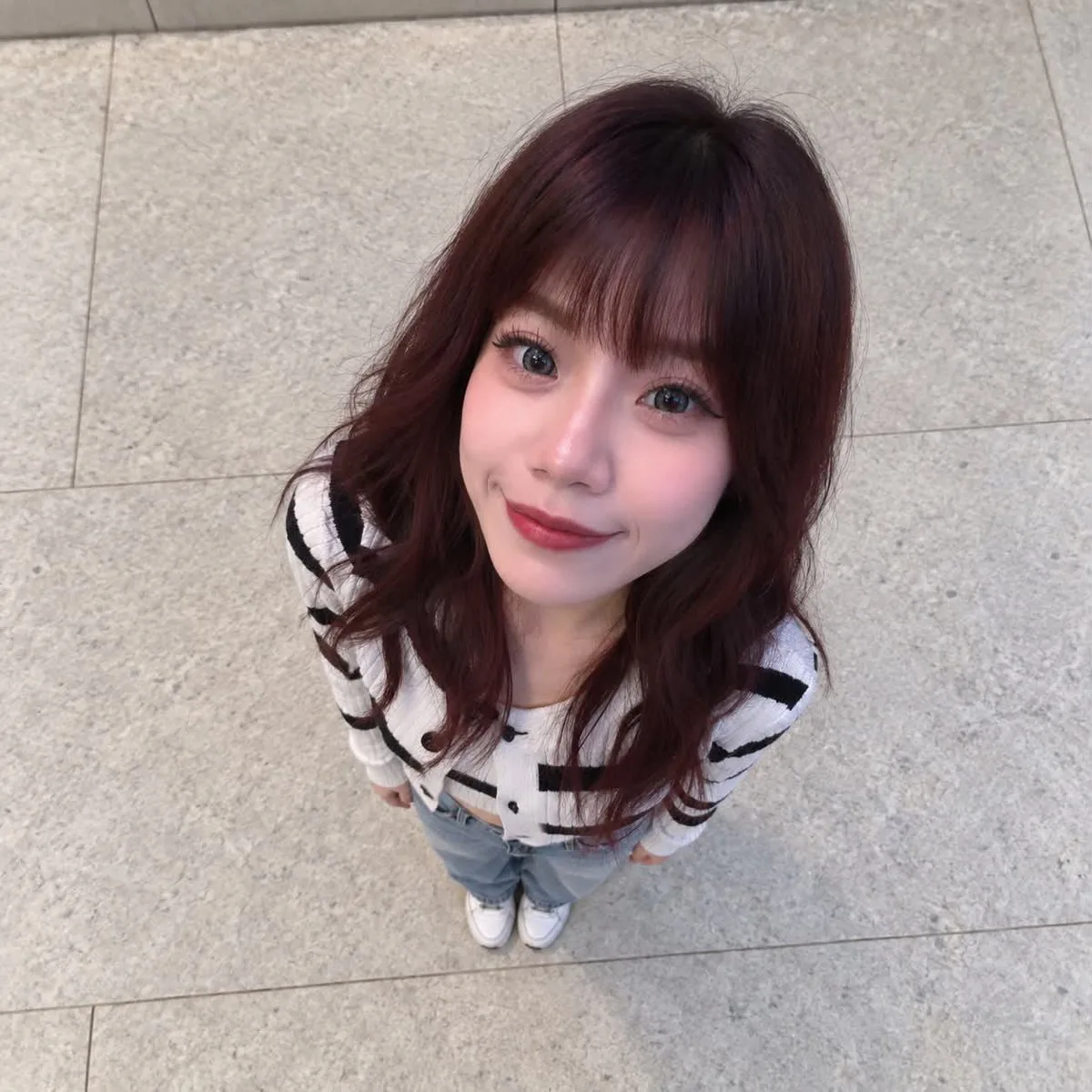 Overhead photo of a person with an exaggerated large head and tiny body on stone flooring. (2)