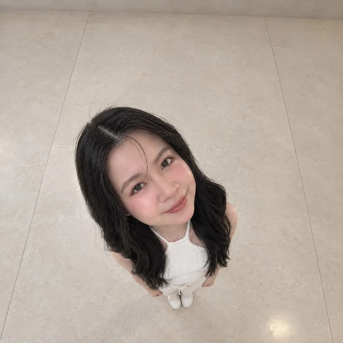 Overhead photo of a person with an exaggerated large head and tiny body on stone flooring. (3)