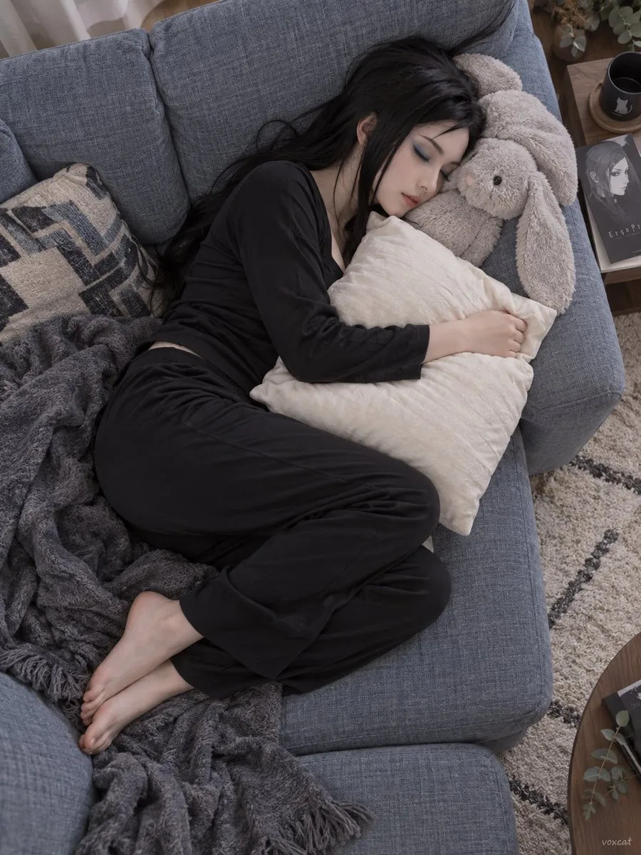 Overhead view of a person sleeping peacefully on a cozy sofa hugging a pillow. (2)