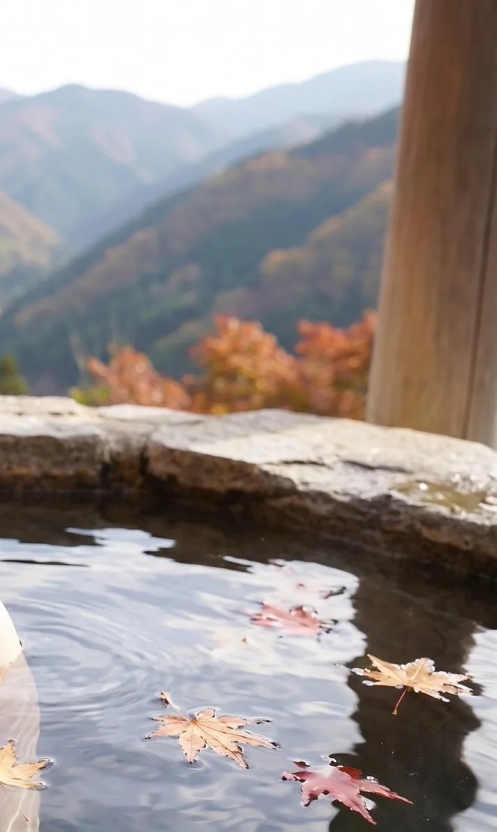 A woman relaxing in a Japanese hot spring surrounded by autumn maple leaves. (3)