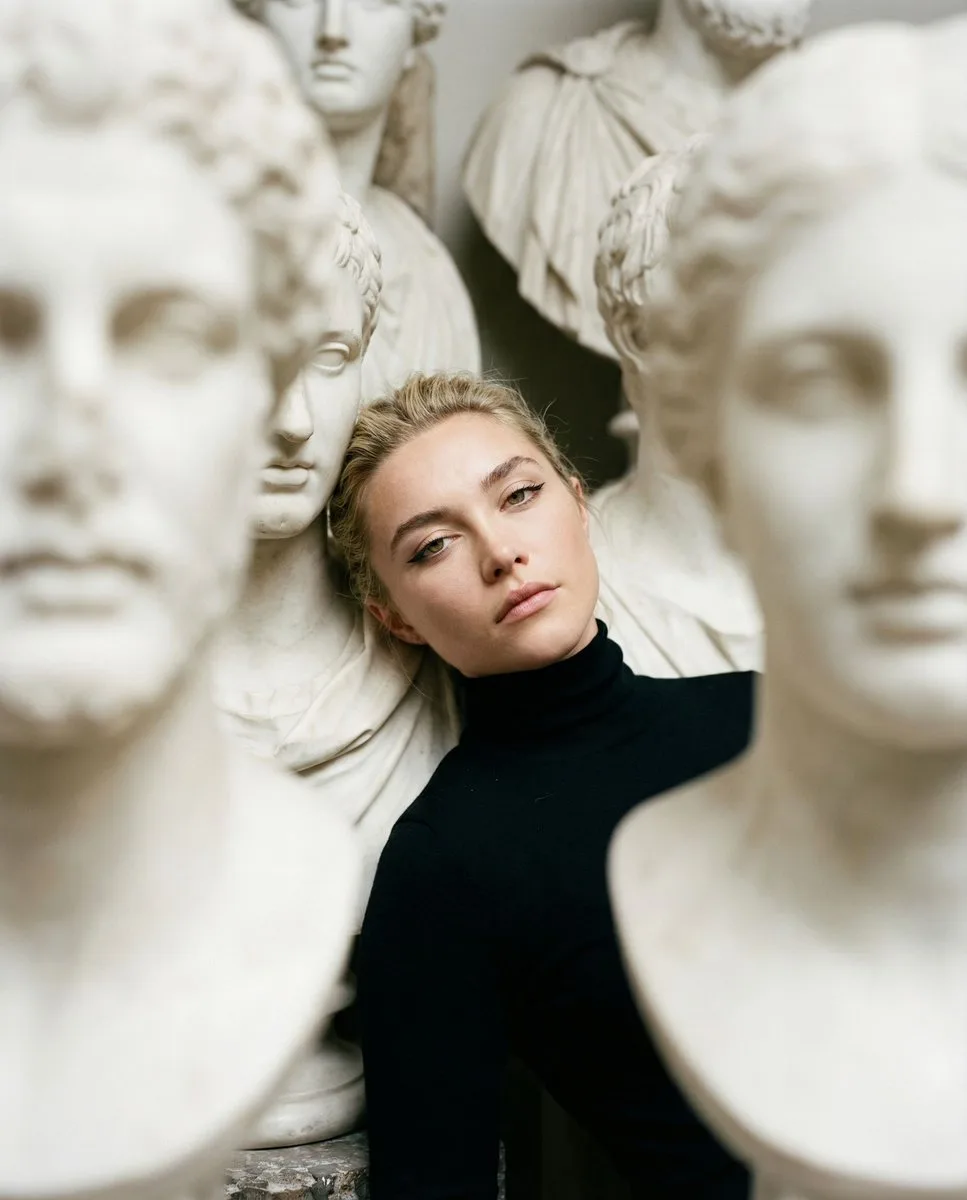 Woman in black turtleneck among dense white marble busts. (3)