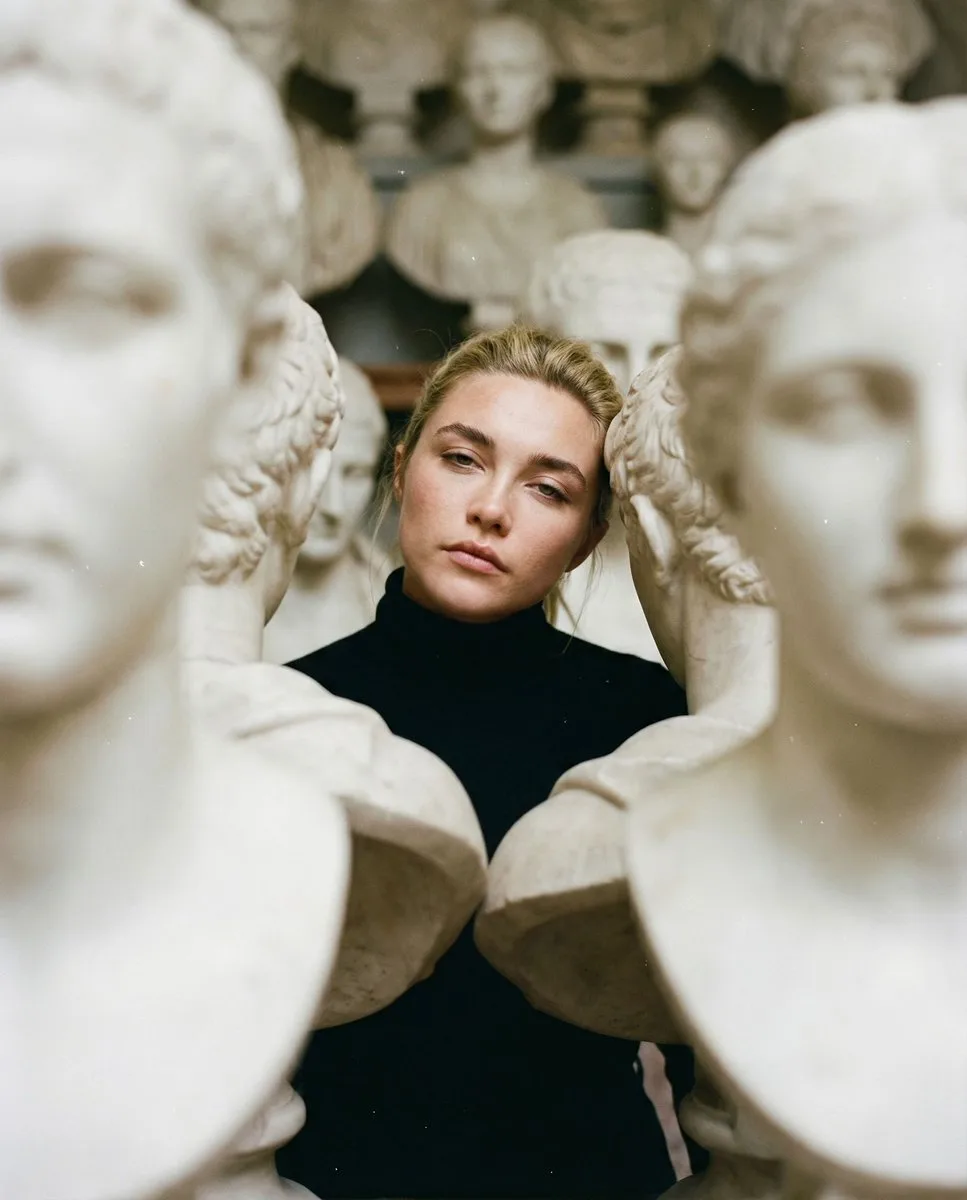 Woman in black turtleneck among dense white marble busts. (4)