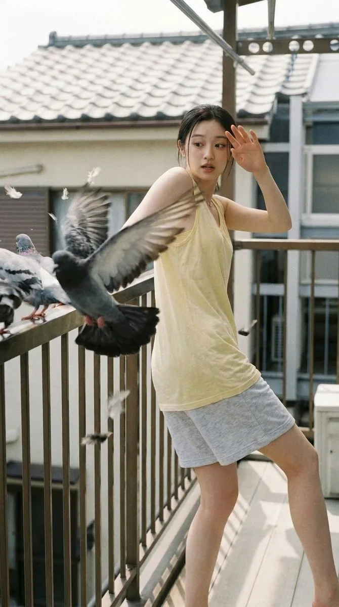 A woman reacting with shock as a bird flies past her face in a park.